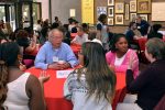 DEEPennSTEM participants talking to a Penn professor at breakfast in large hall