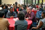 DEEPennSTEM participants talking to a Penn professor at breakfast in large hall