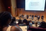 panel of grad students on stage as seen from the audience